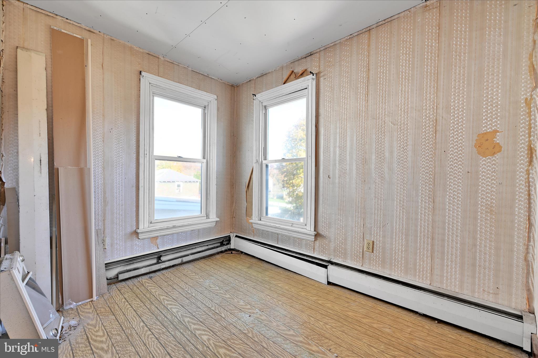 61 Mifflin Street Pine Grove, PA 17963 - Photo 15 of 31 an empty room with wooden floor and windows with curtains