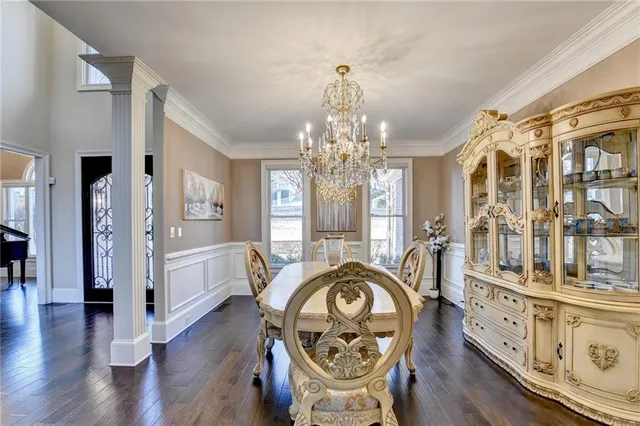 a view of a dining room with furniture a chandelier and wooden floor