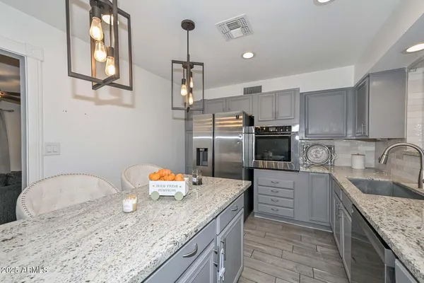 a kitchen with stainless steel appliances granite countertop a sink refrigerator and microwave