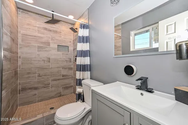 a bathroom with a sink a toilet and shower