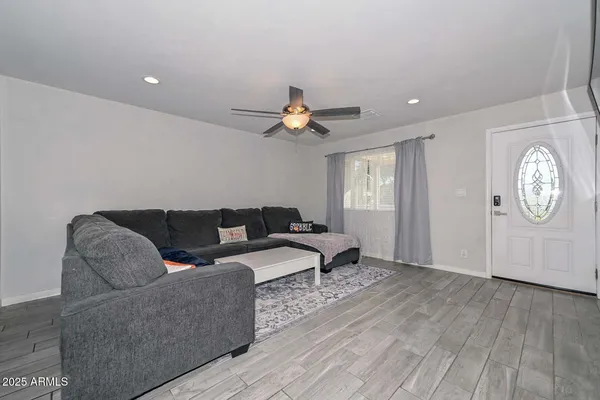 a living room with furniture a chandelier and a window