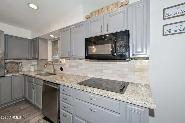 a kitchen with stainless steel appliances granite countertop a sink stove and microwave