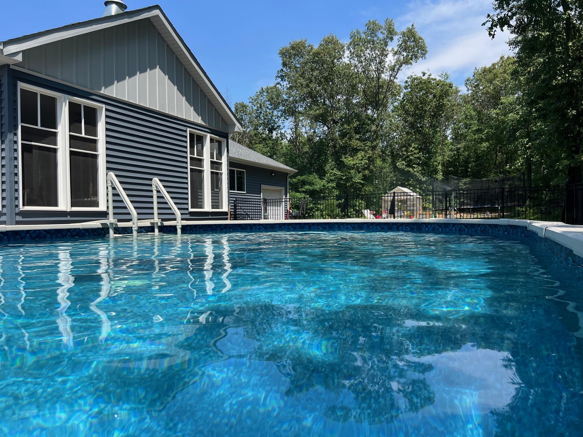 6795 Whispering Woods Drive Demotte, IN 46310 - Photo 15 of 64 a house view with swimming pool in front of it