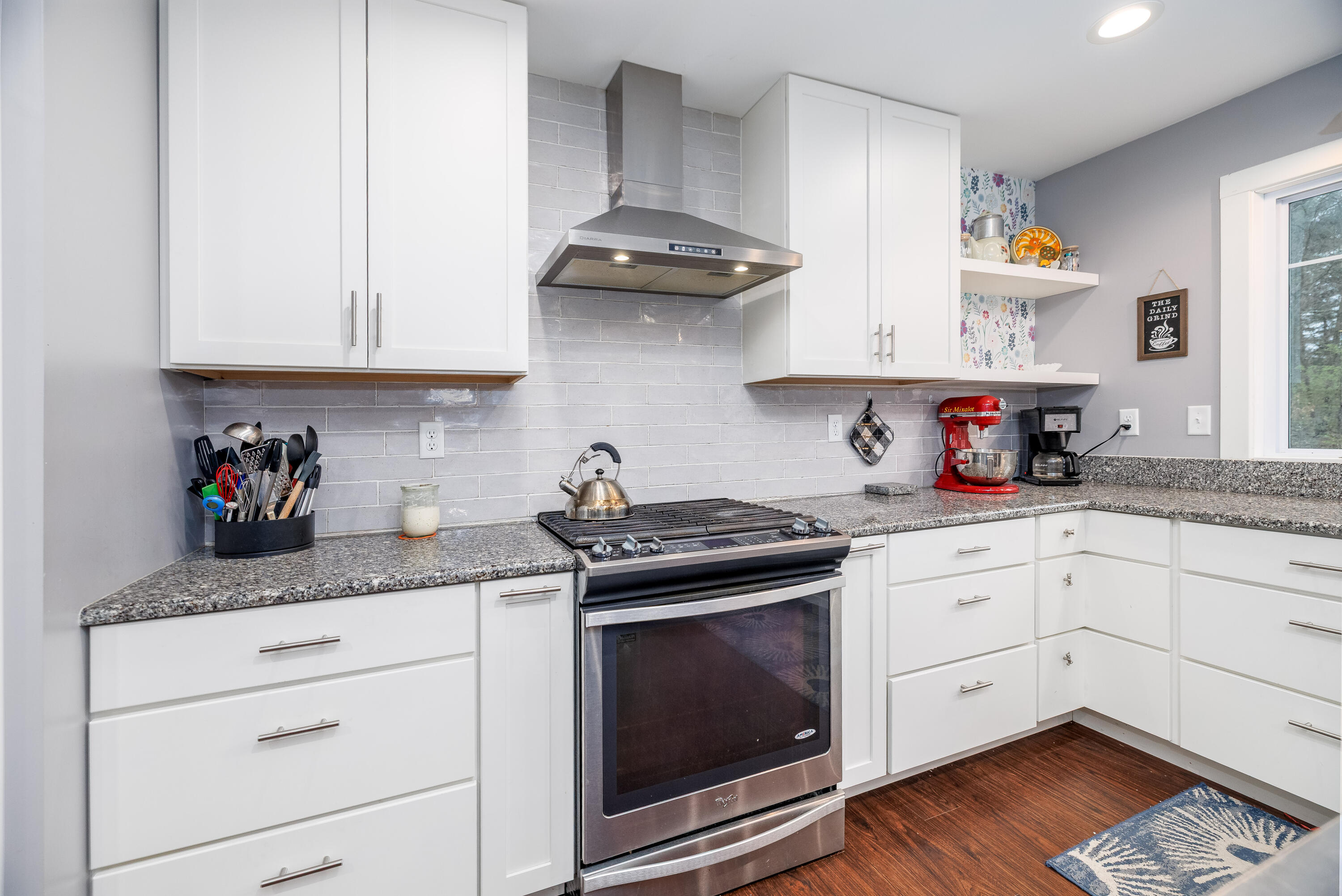 6795 Whispering Woods Drive Demotte, IN 46310 - Photo 25 of 64 a kitchen with stainless steel appliances granite countertop a stove a sink dishwasher and cabinets with wooden floor