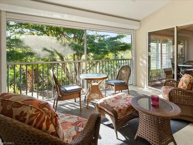 a living room with furniture and floor to ceiling windows