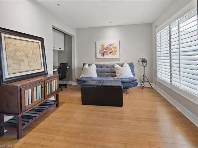 a living room with furniture stairs and a window