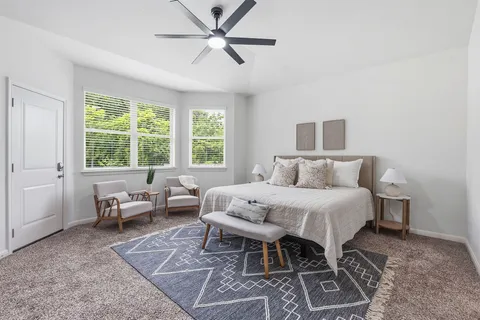 a spacious bedroom with a bed and a window