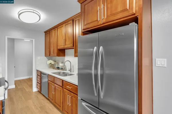 a kitchen that has a lot of cabinets stainless steel appliances and a counter top space