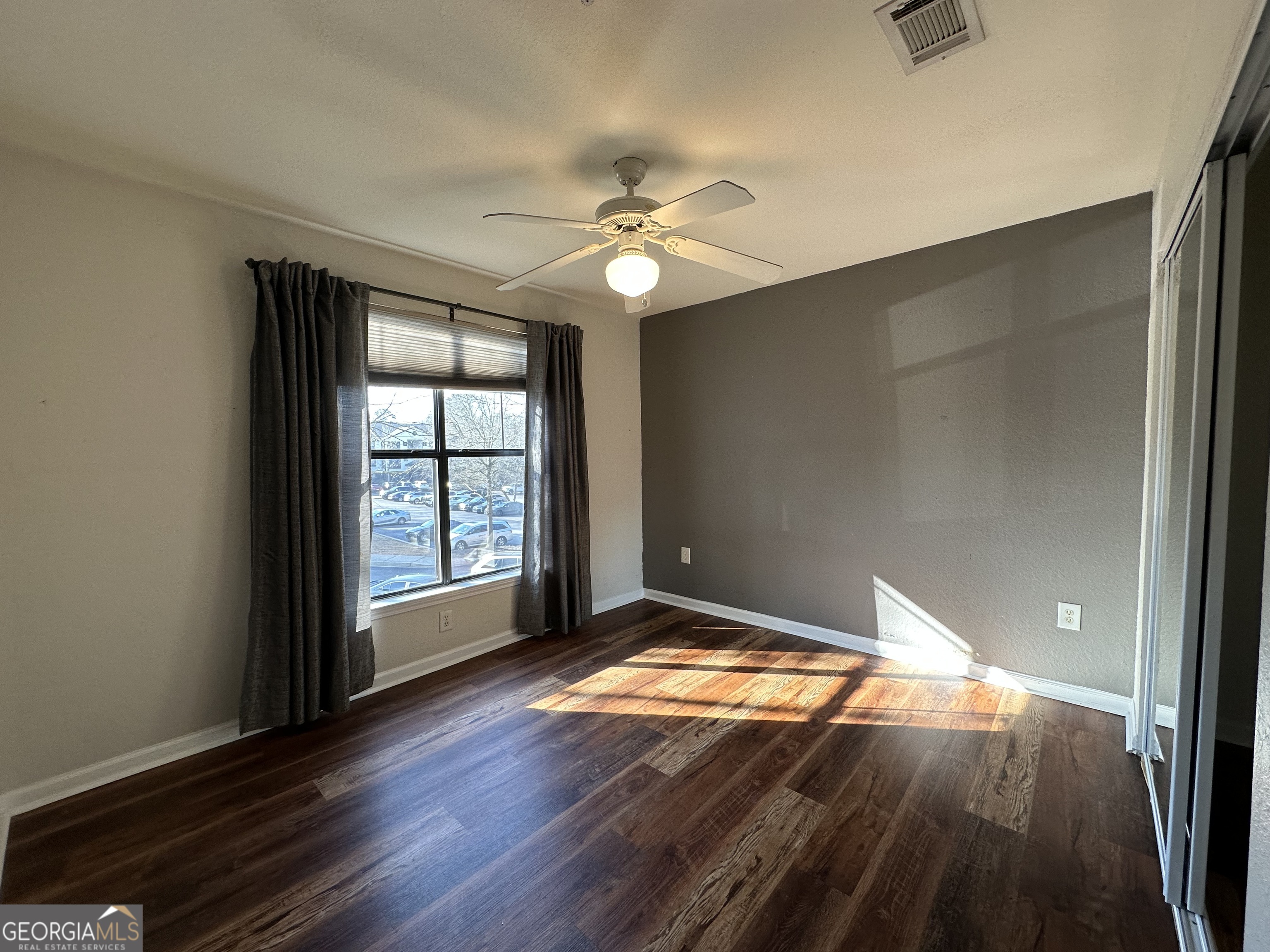 211 North Avenue Athens, GA 30601 - Photo 14 of 18 an empty room with wooden floor chandelier fan and windows
