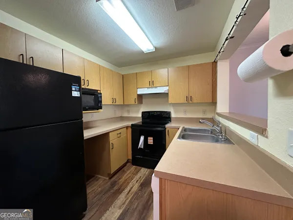 a kitchen with a refrigerator and a sink