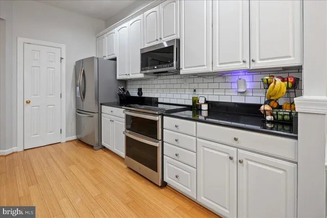 a kitchen with stainless steel appliances granite countertop a refrigerator and a stove top oven