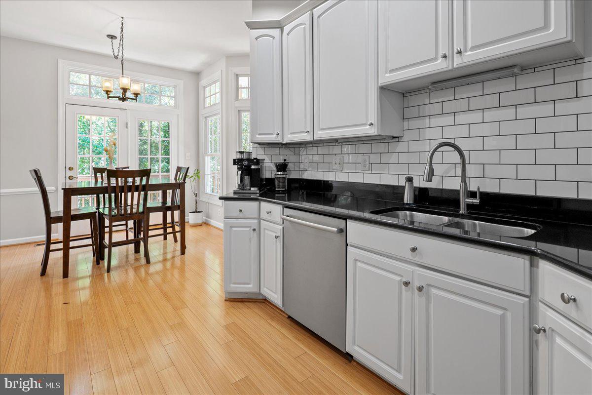 6347 Simmer Circle Springfield, VA 22150 - Photo 22 of 47 a kitchen with stainless steel appliances granite countertop a table chairs sink and cabinets