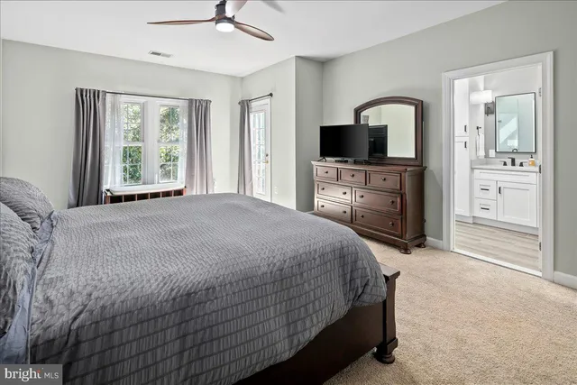 a bathroom with white cabinets and sink