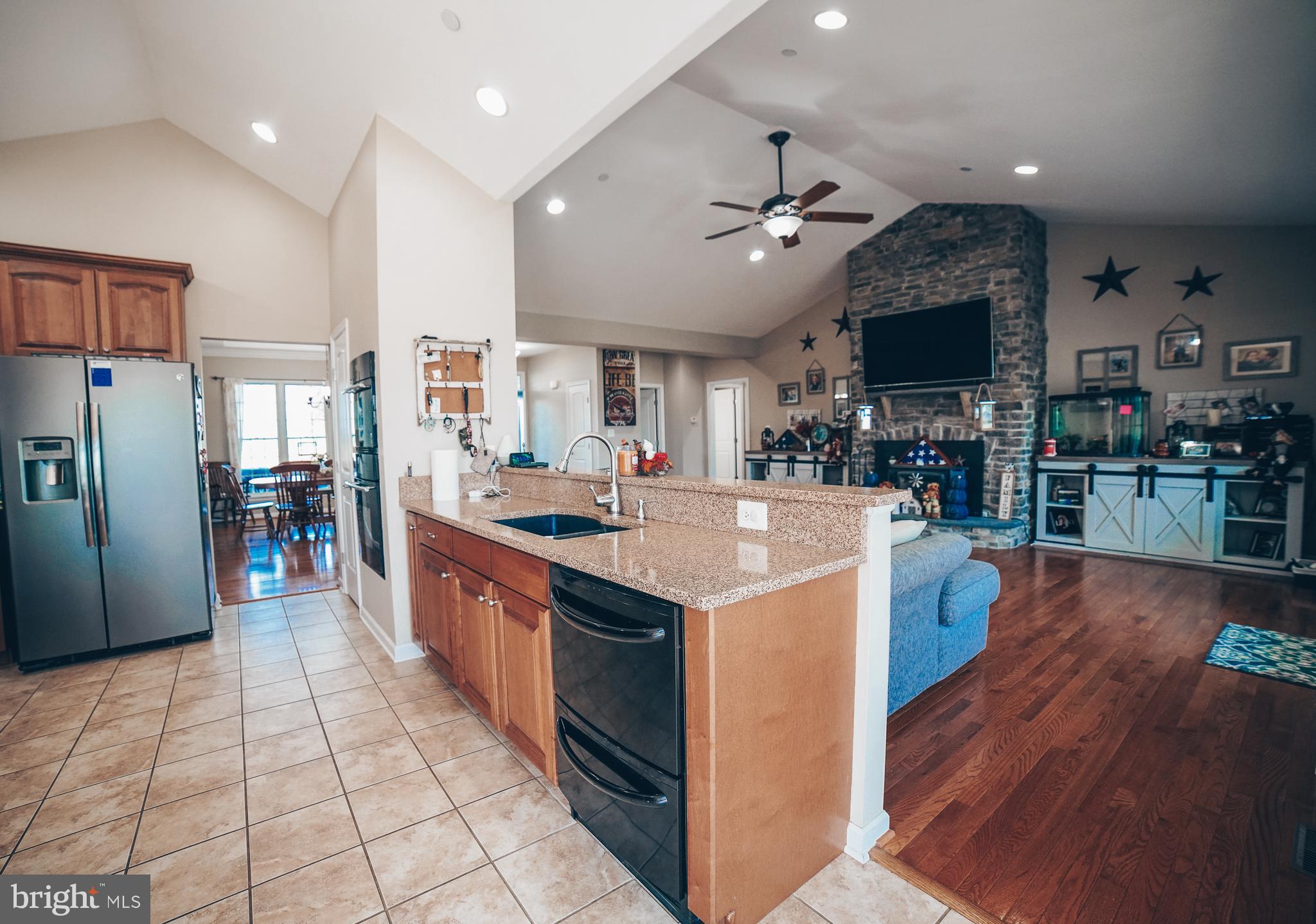 125 South Clear Ridge Road Union Bridge, MD 21791 - Photo 7 of 25 a kitchen with stainless steel appliances granite countertop a large stove top oven a sink dishwasher and a refrigerator with wooden floor