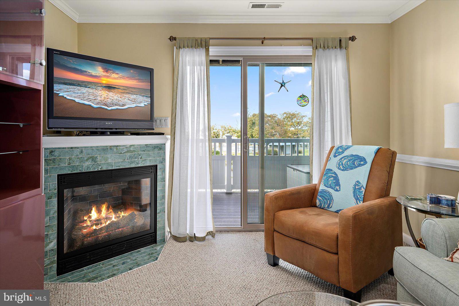 201 South Heron Drive, Unit 2D Ocean City, MD 21842 - Photo 10 of 61 a living room with furniture a flat screen tv and a fireplace