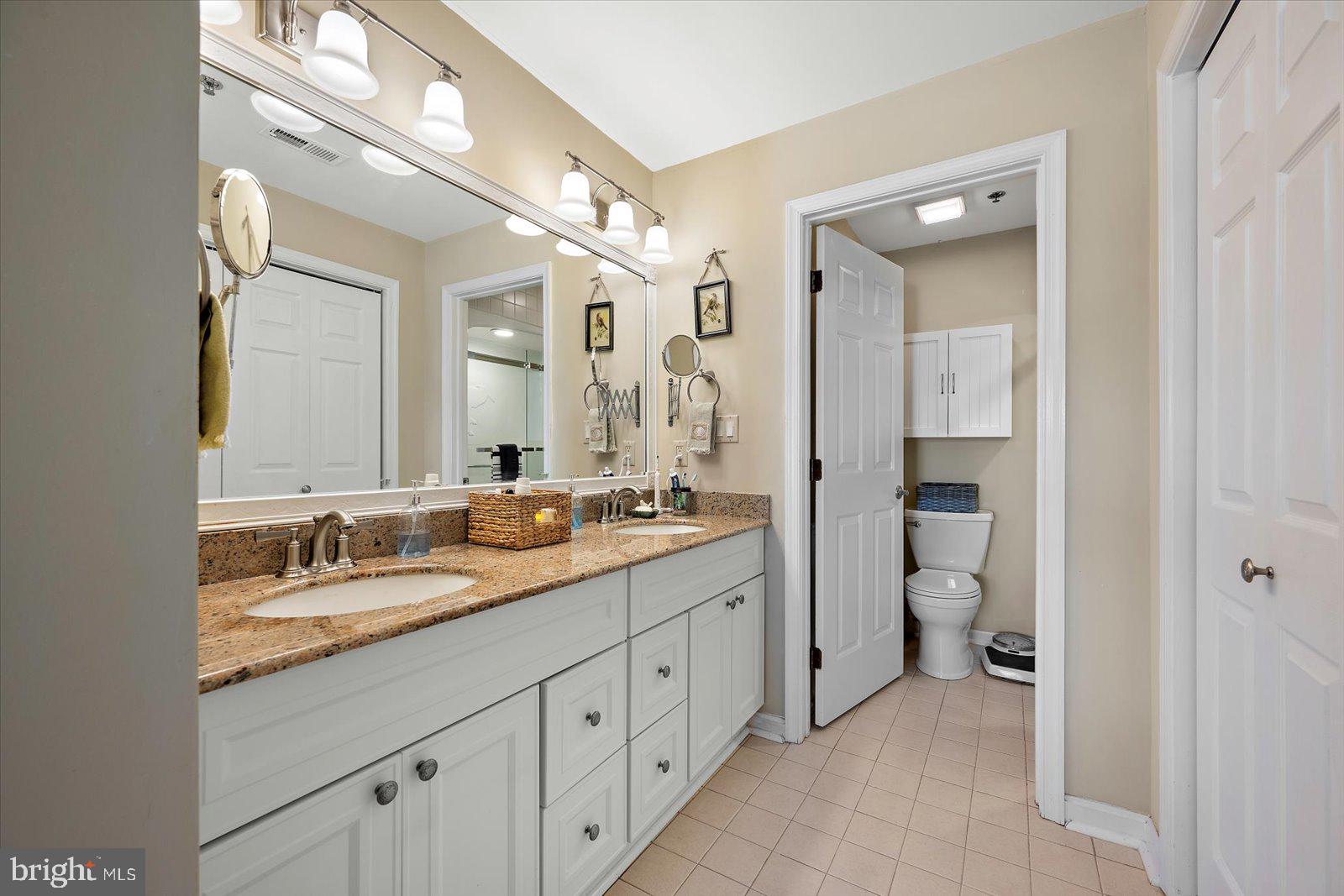 201 South Heron Drive, Unit 2D Ocean City, MD 21842 - Photo 17 of 61 a spacious bathroom with a granite countertop sink mirror and toilet