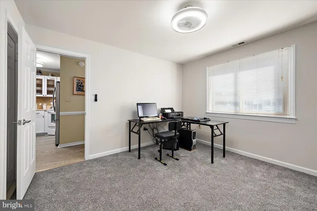 a view of a workspace with furniture and a window