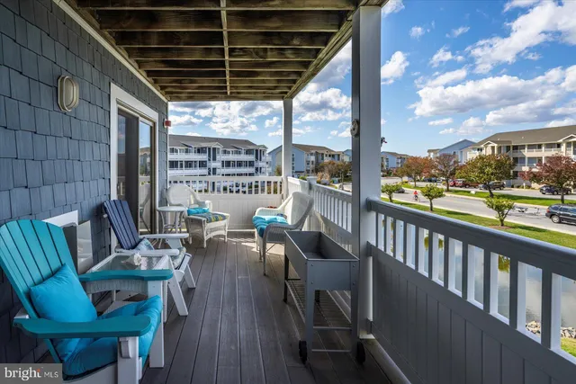 a balcony with wooden floor and outdoor seating