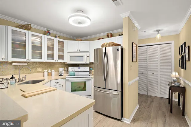 a kitchen with stainless steel appliances a refrigerator a sink a stove and cabinets