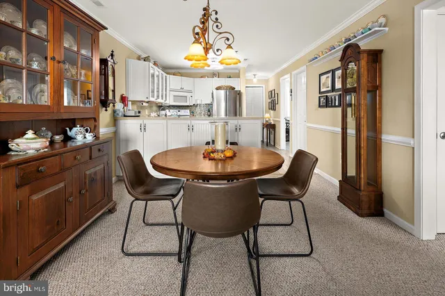 a dining room filled chandelier and wooden furniture