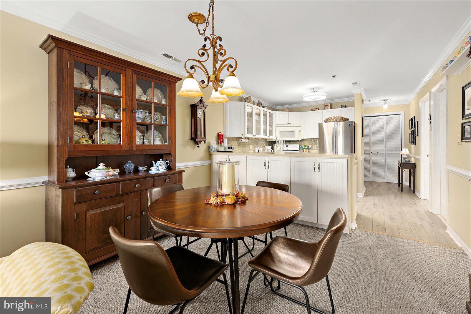 201 South Heron Drive, Unit 2D Ocean City, MD 21842 - Photo 9 of 61 a dining room filled chandelier and wooden furniture