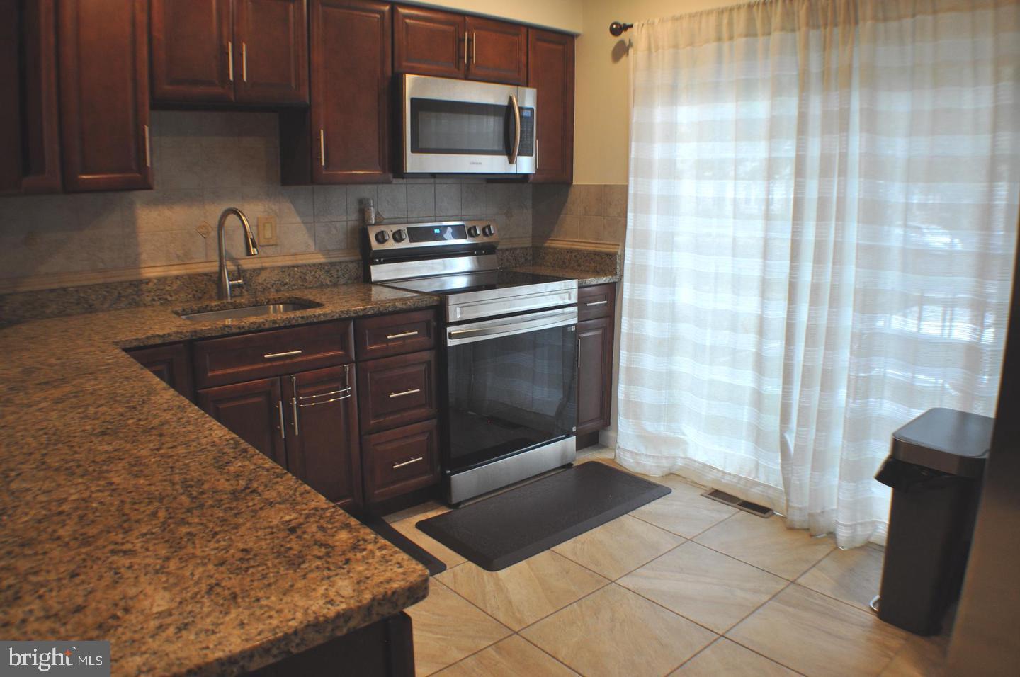 14613 Tynewick Terrace, Unit 61461 Silver Spring, MD 20906 - Photo 8 of 30 a kitchen with a sink and a stove top oven