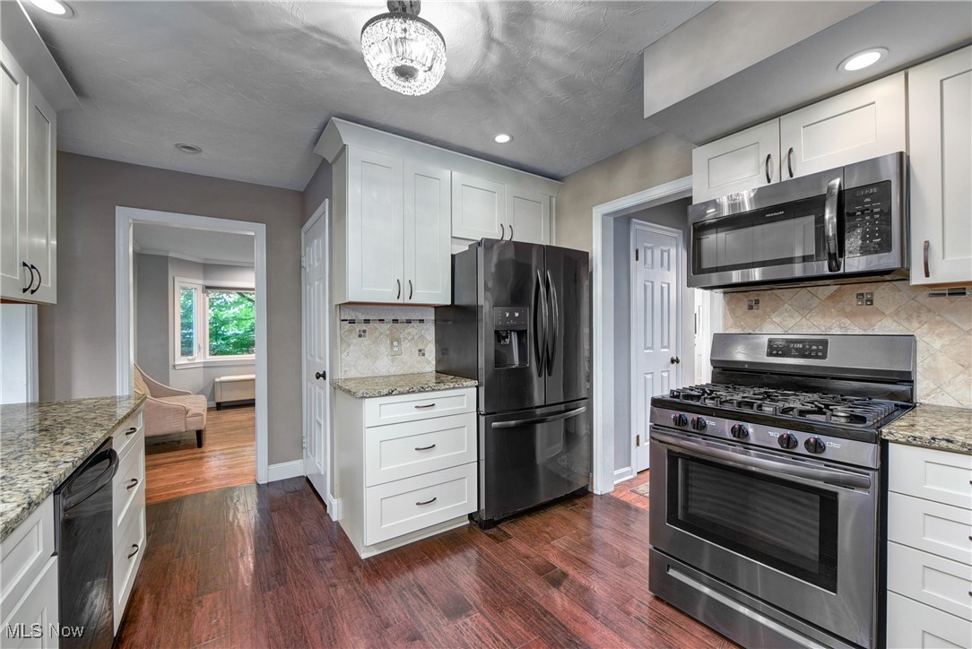456 Clague Road Bay Village, OH 44140 - Photo 8 of 28 Kitchen with newer cabinets and appliances (2019). Travertine backplash and granite counters.