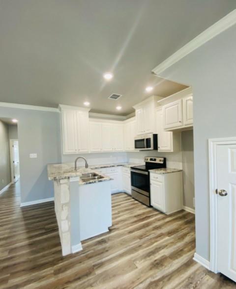 716 South Main Street, Unit 718 McGregor, TX 76657 - Photo 4 of 12 a kitchen with a stove a sink and a refrigerator