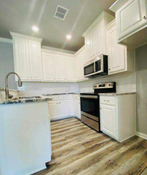 716 South Main Street, Unit 718 McGregor, TX 76657 - Photo 5 of 12 a kitchen with stainless steel appliances granite countertop a stove a sink and a microwave