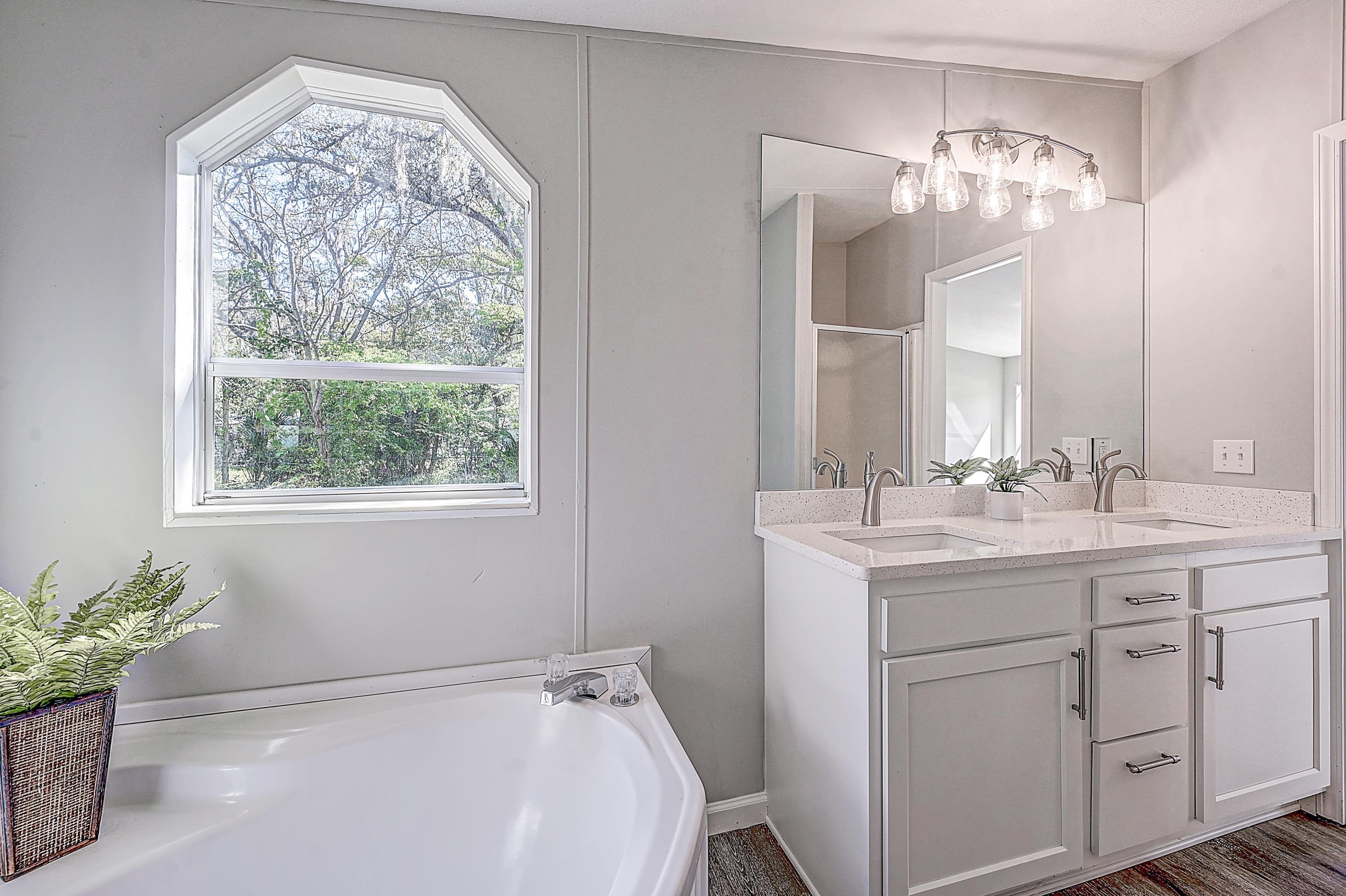 800 Oakes Avenue St. Augustine, FL 32084 - Photo 6 of 26 a spacious bathroom with a granite countertop sink a large mirror a vanity and a window