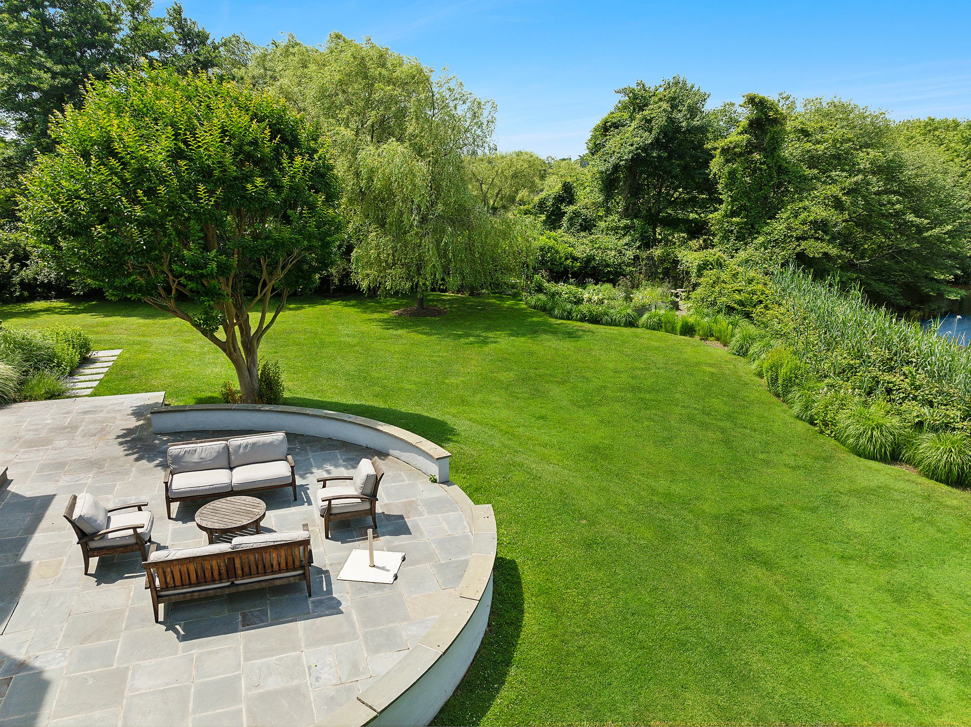 153 Egypt Lane East Hampton, NY 11937 - Photo 4 of 47 a view of a backyard with couches with wooden floor and fence