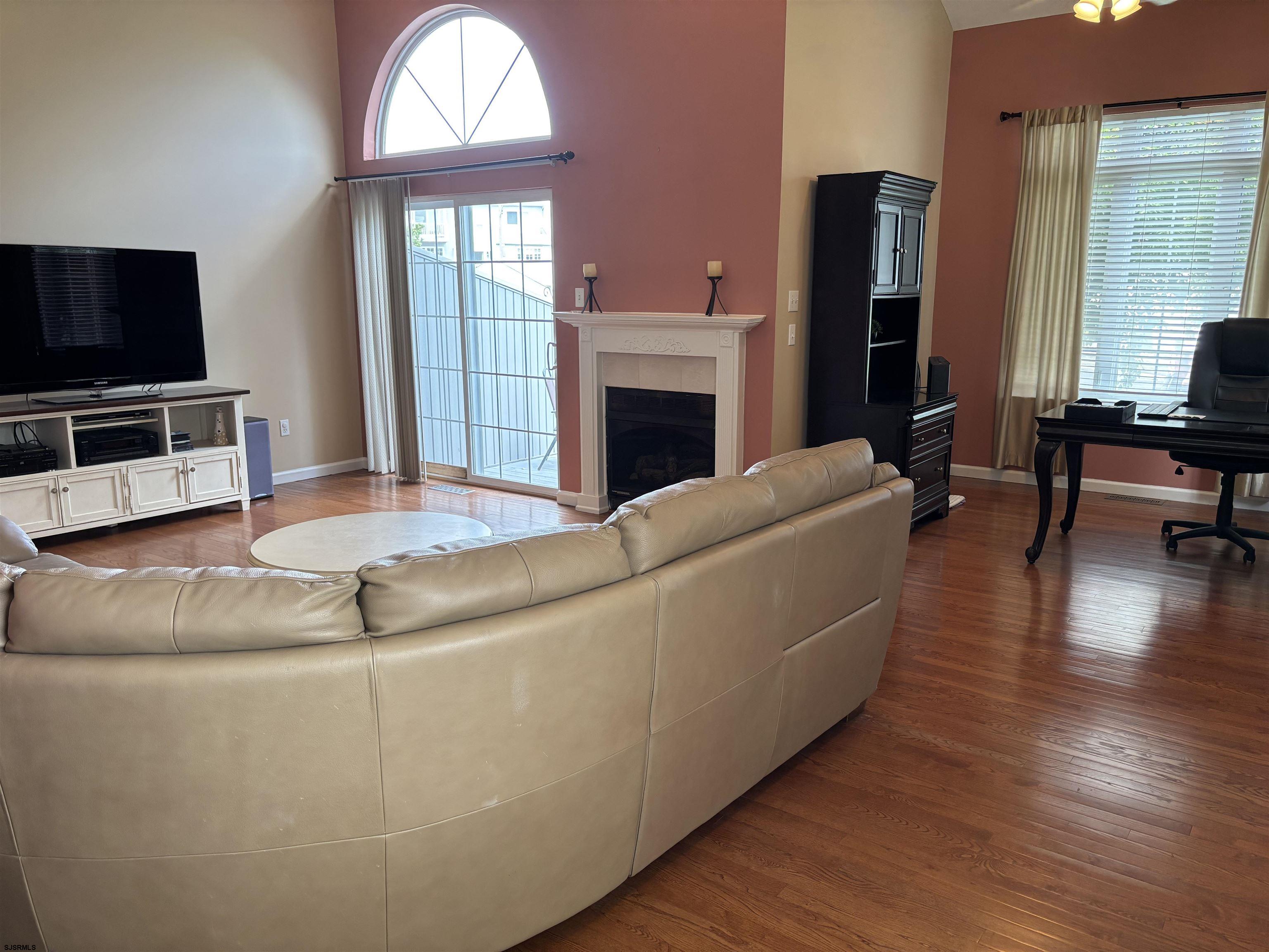 66 Sailfish Drive Brigantine, NJ 08203 - Photo 11 of 24 a living room with furniture a fireplace and a flat screen tv