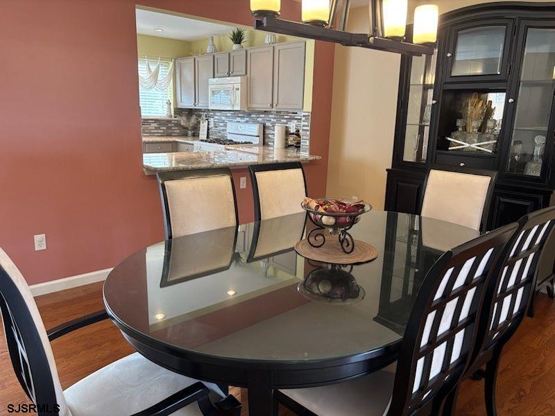 66 Sailfish Drive Brigantine, NJ 08203 - Photo 14 of 24 a view of a dining room with furniture a rug and wooden floor