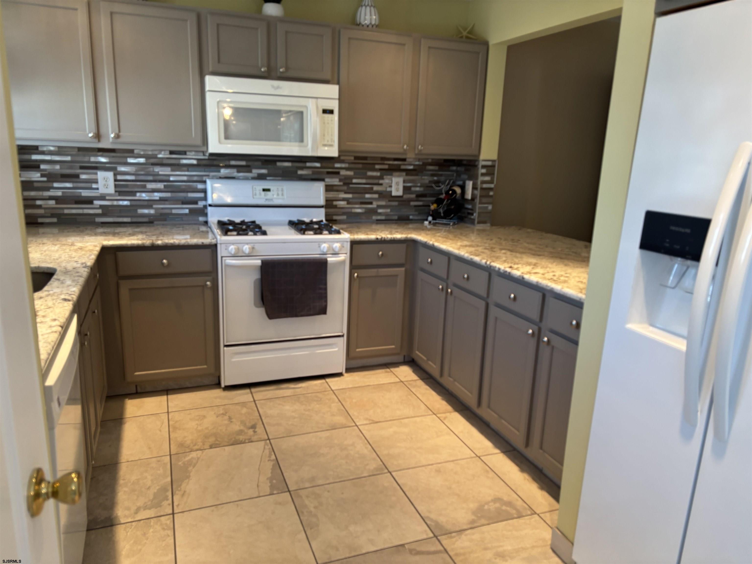 66 Sailfish Drive Brigantine, NJ 08203 - Photo 16 of 24 a kitchen with a stove top oven and cabinets