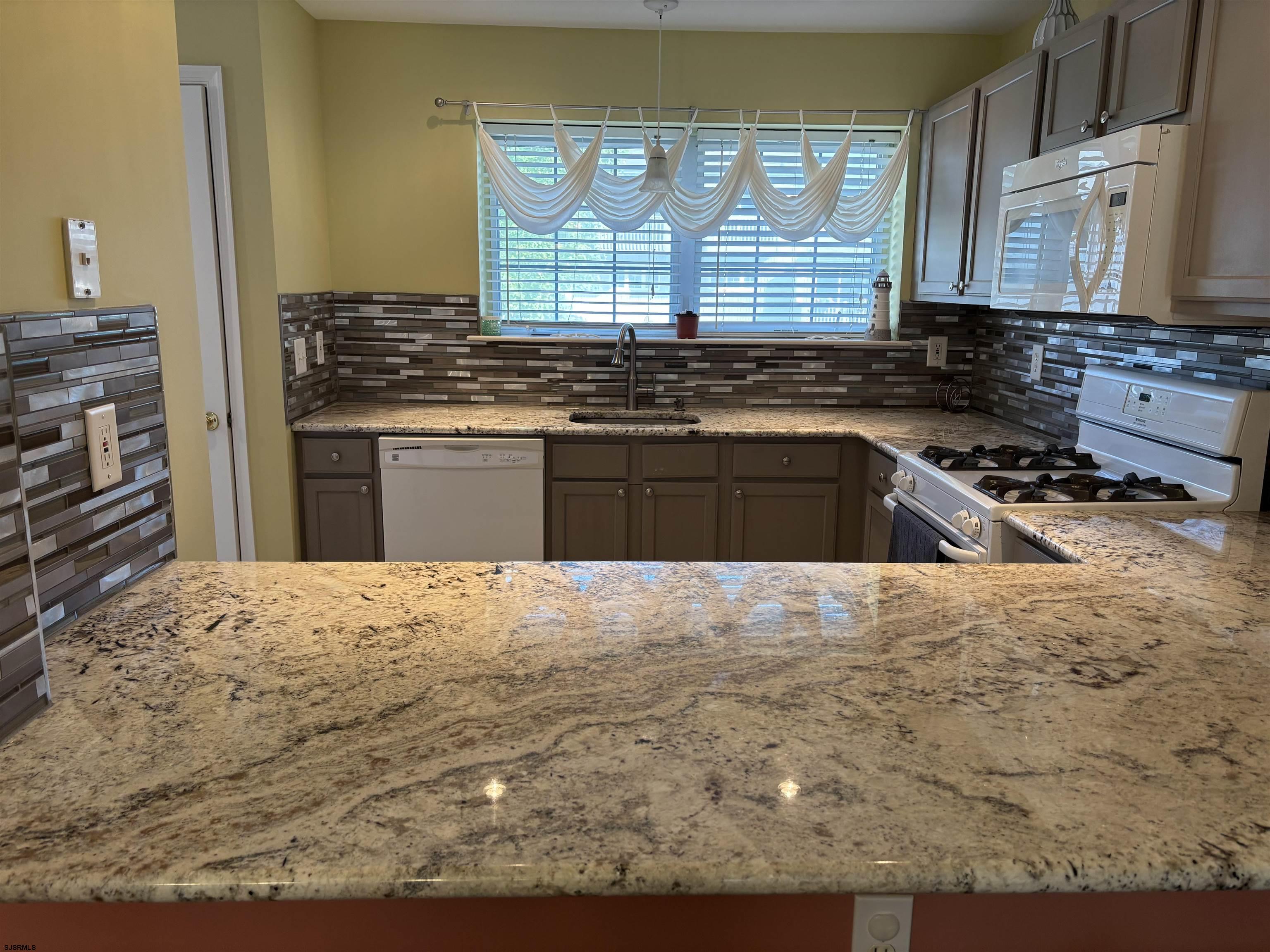66 Sailfish Drive Brigantine, NJ 08203 - Photo 17 of 24 a kitchen with a stove a sink and a granite counter tops