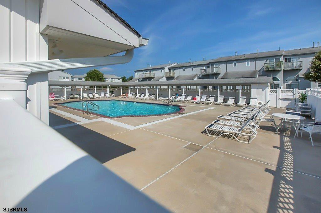 66 Sailfish Drive Brigantine, NJ 08203 - Photo 6 of 24 a view of a patio with dining table and chairs under an umbrella