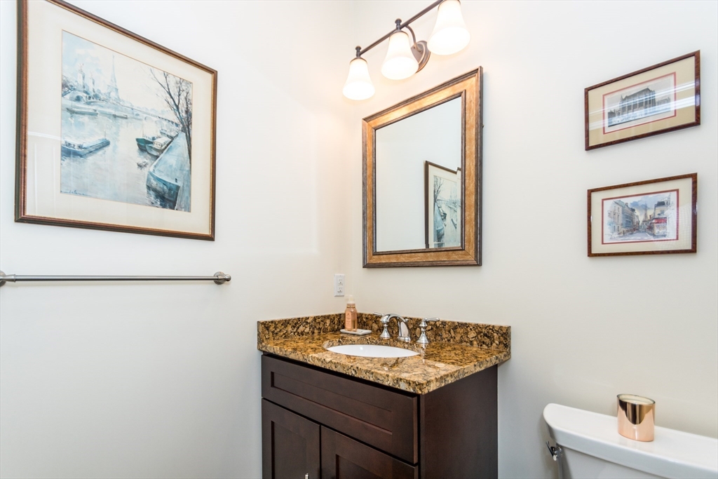 128 Church Street, Unit 2 Waltham, MA 02452 - Photo 17 of 41 a bathroom with a granite countertop sink a mirror and a picture on the wall