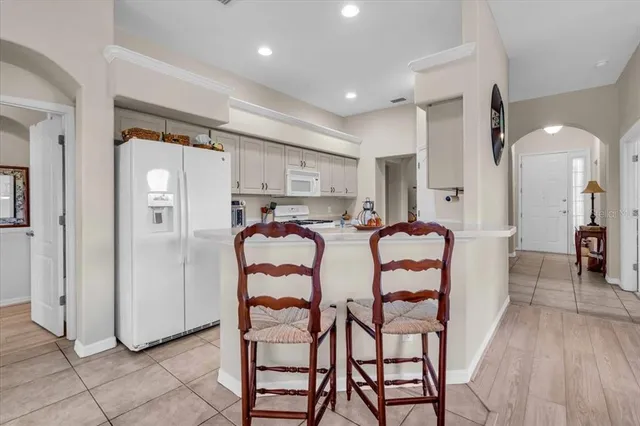 a dining area with stainless steel appliances kitchen island granite countertop a refrigerator and cabinets