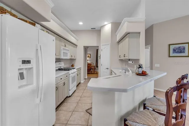 a kitchen with stainless steel appliances a sink a stove a refrigerator and cabinets
