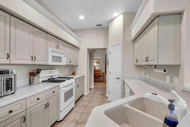 a kitchen with white cabinets and appliances