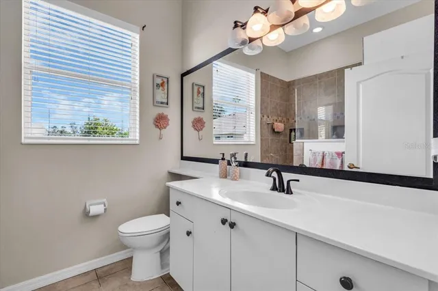 a bathroom with a sink a large mirror and a light fixture