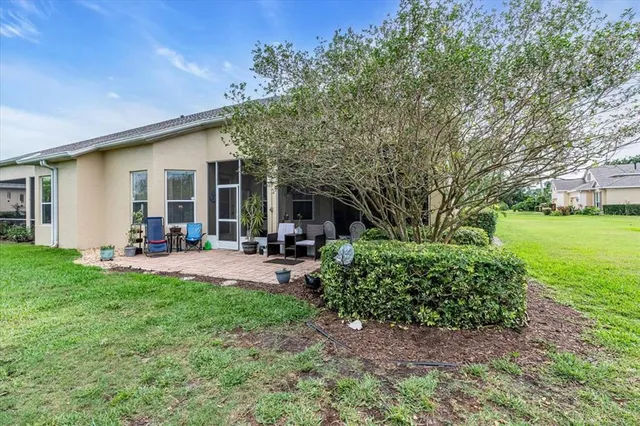 a view of a house with backyard and sitting area