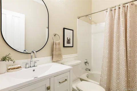 a bathroom with a sink mirror and a toilet