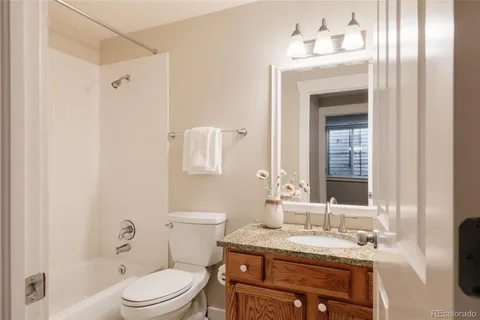 a bathroom with a granite countertop sink toilet a mirror and shower