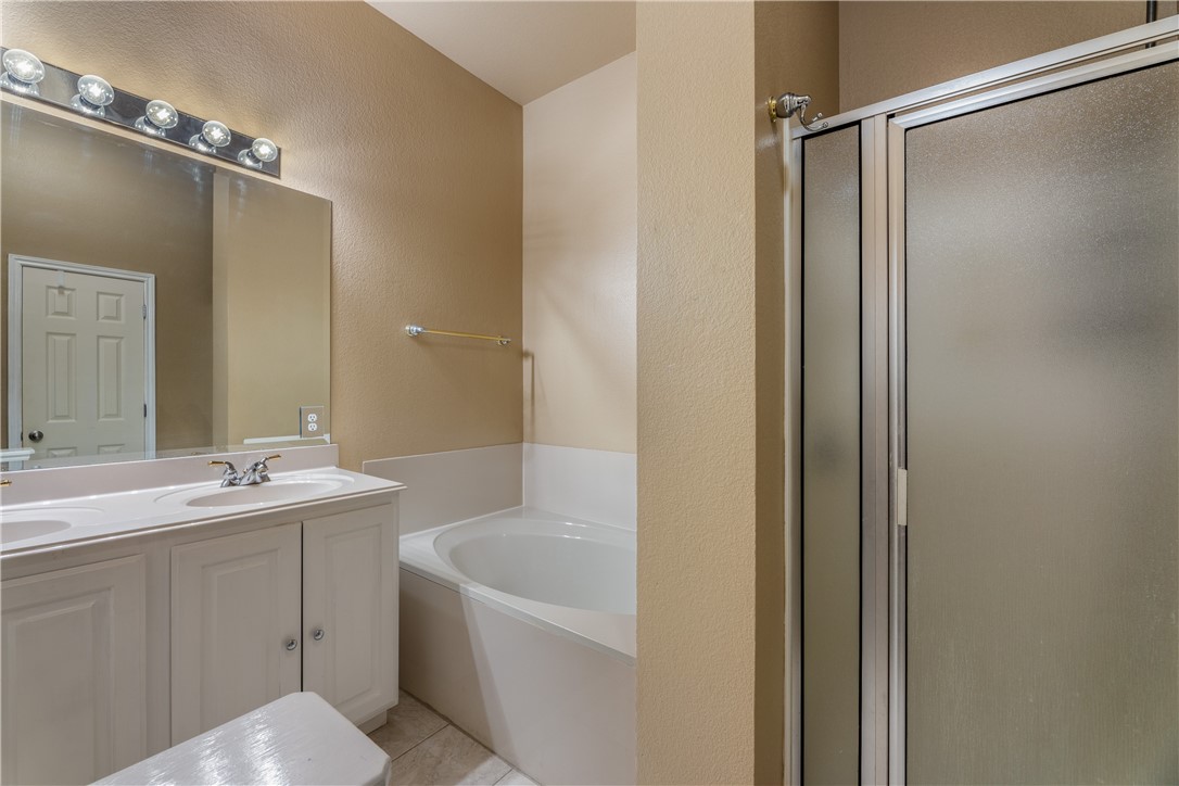 114 Inman Drive Hutto, TX 78634 - Photo 17 of 20 a bathroom with a tub sink shower and mirror