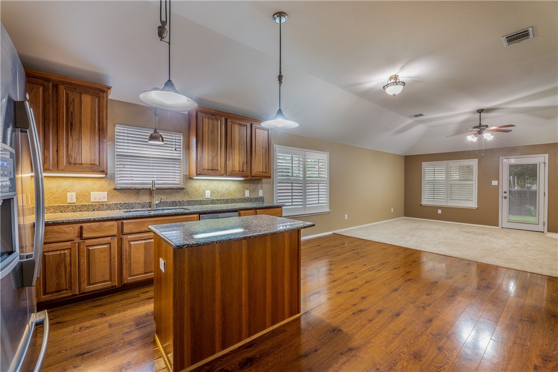 114 Inman Drive Hutto, TX 78634 - Photo 7 of 20 a kitchen with stainless steel appliances granite countertop wooden floors and granite counter tops