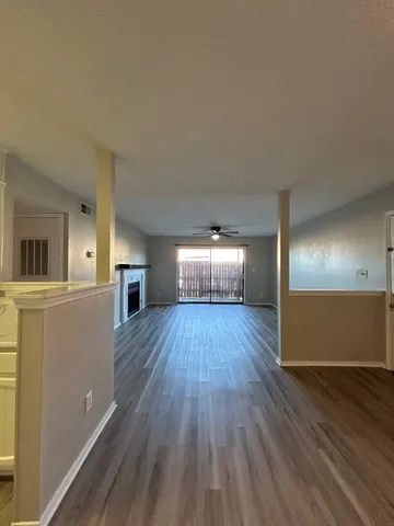 a view of empty room with wooden floor