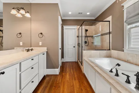 a spacious bathroom with a double vanity sink a mirror and a bathtub