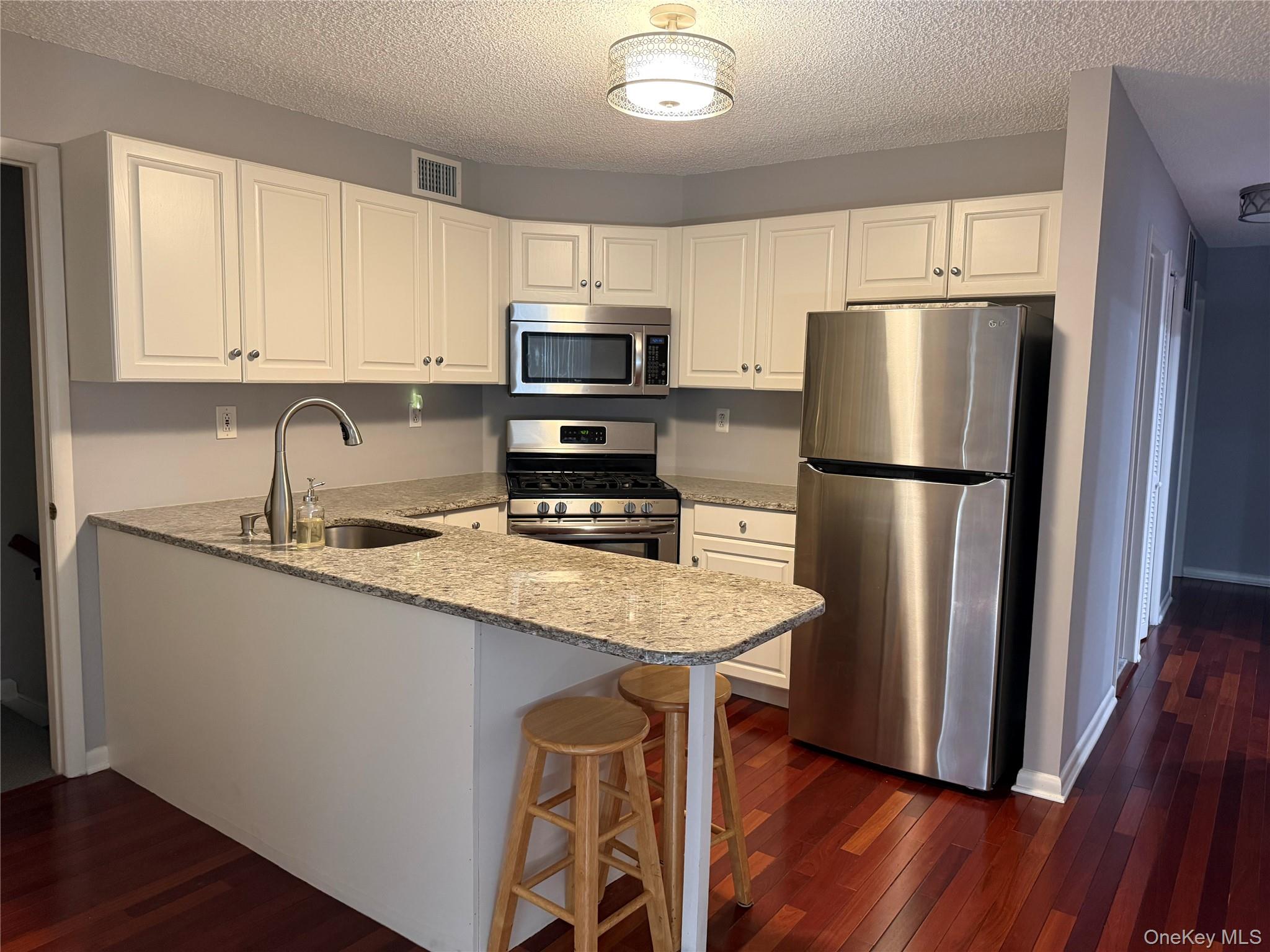 88 Eagle Ridge Way Nanuet, NY 10954 - Photo 9 of 16 a kitchen with stainless steel appliances granite countertop a refrigerator a sink dishwasher a stove and white countertops with wooden floor