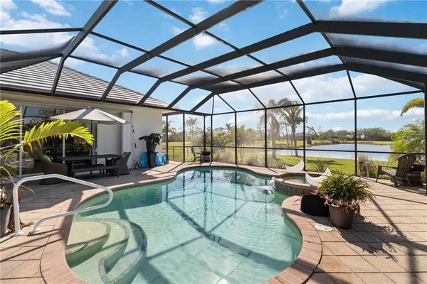 a open kitchen with granite countertop a stove top oven a sink dishwasher a dining table and chairs with wooden floor